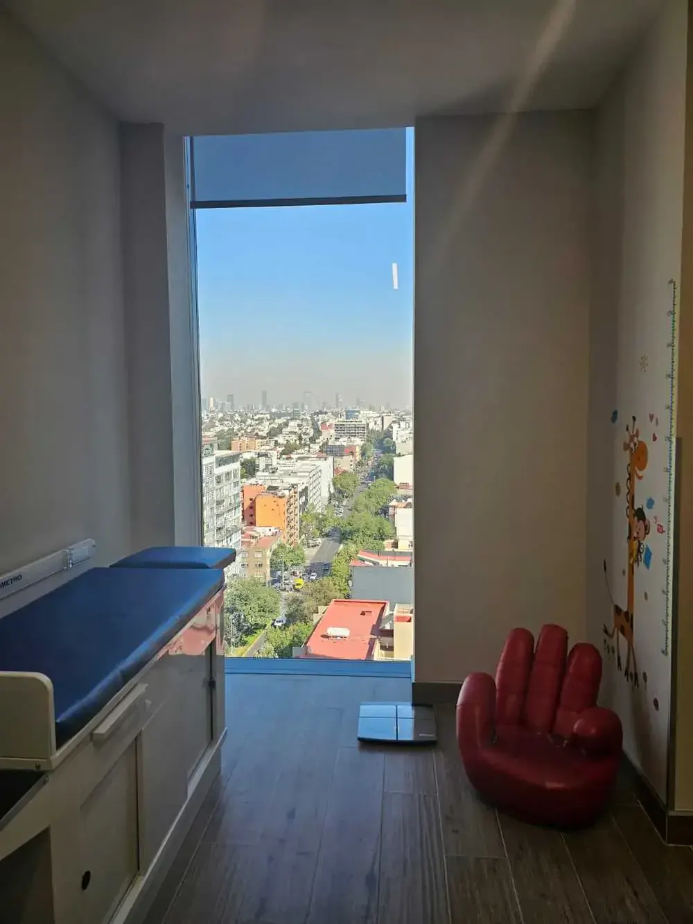 Área de exploración pediátrica con luz natural y vista a la ciudad