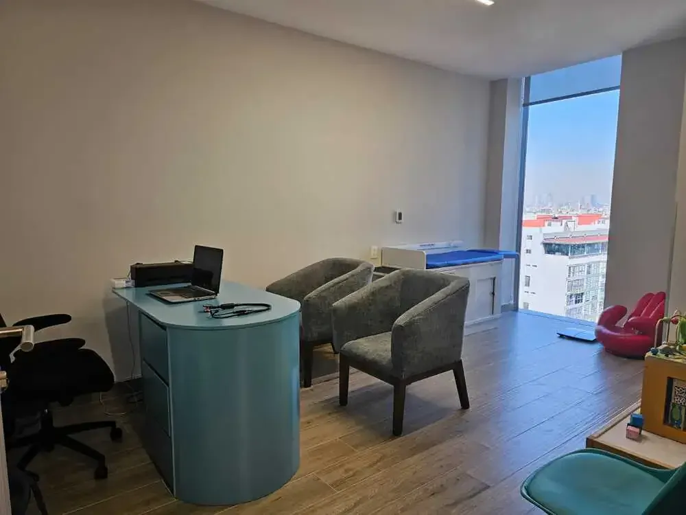 Escritorio de consulta de seguimiento con sillones y vista a la ciudad