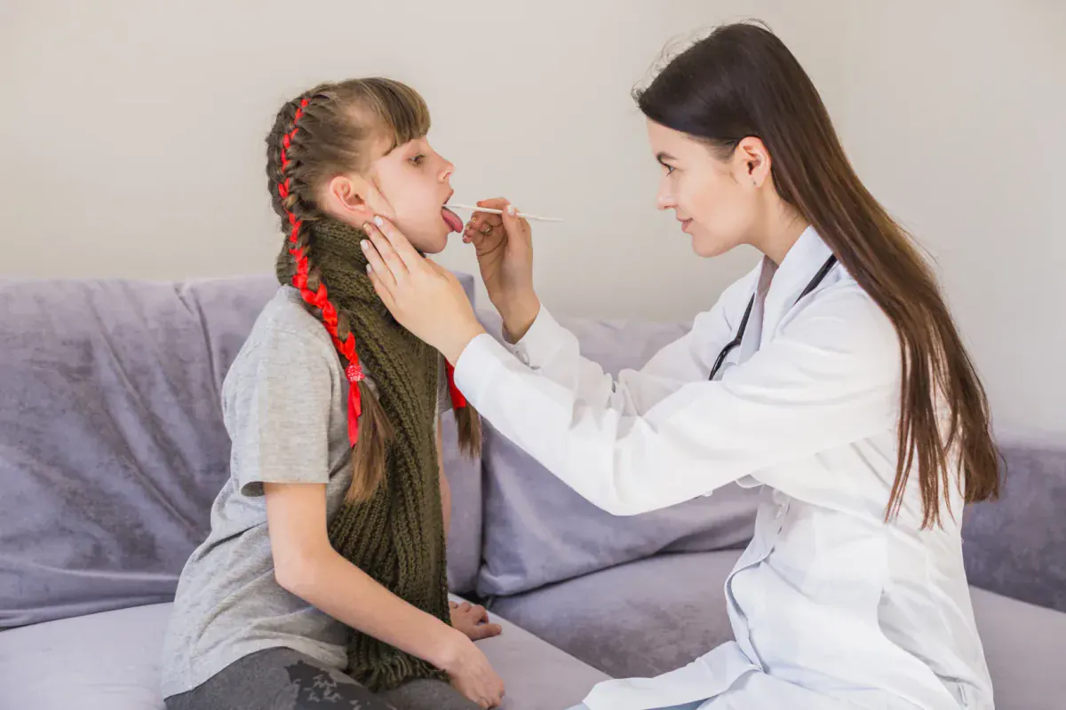 Detección de infecciones respiratorias: doctora revisando la garganta de una niña